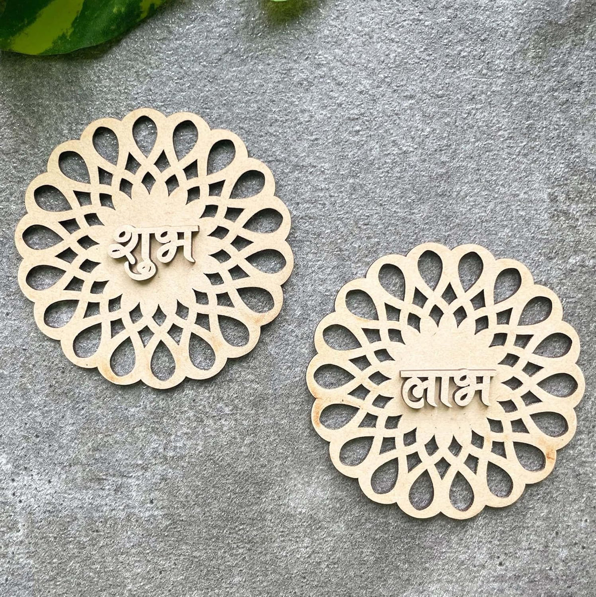 Two decorative wooden pieces with intricate patterns and engraved text on a gray surface.