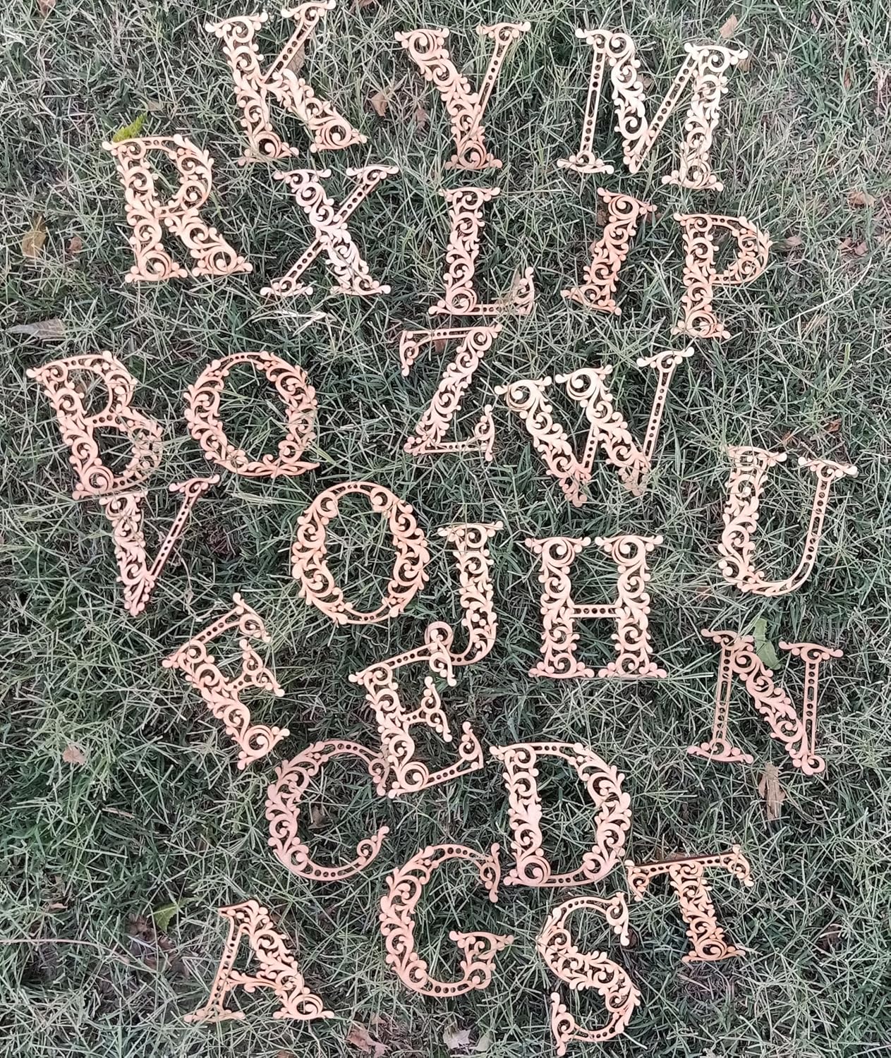 Rose gold metal letters scattered on grass
