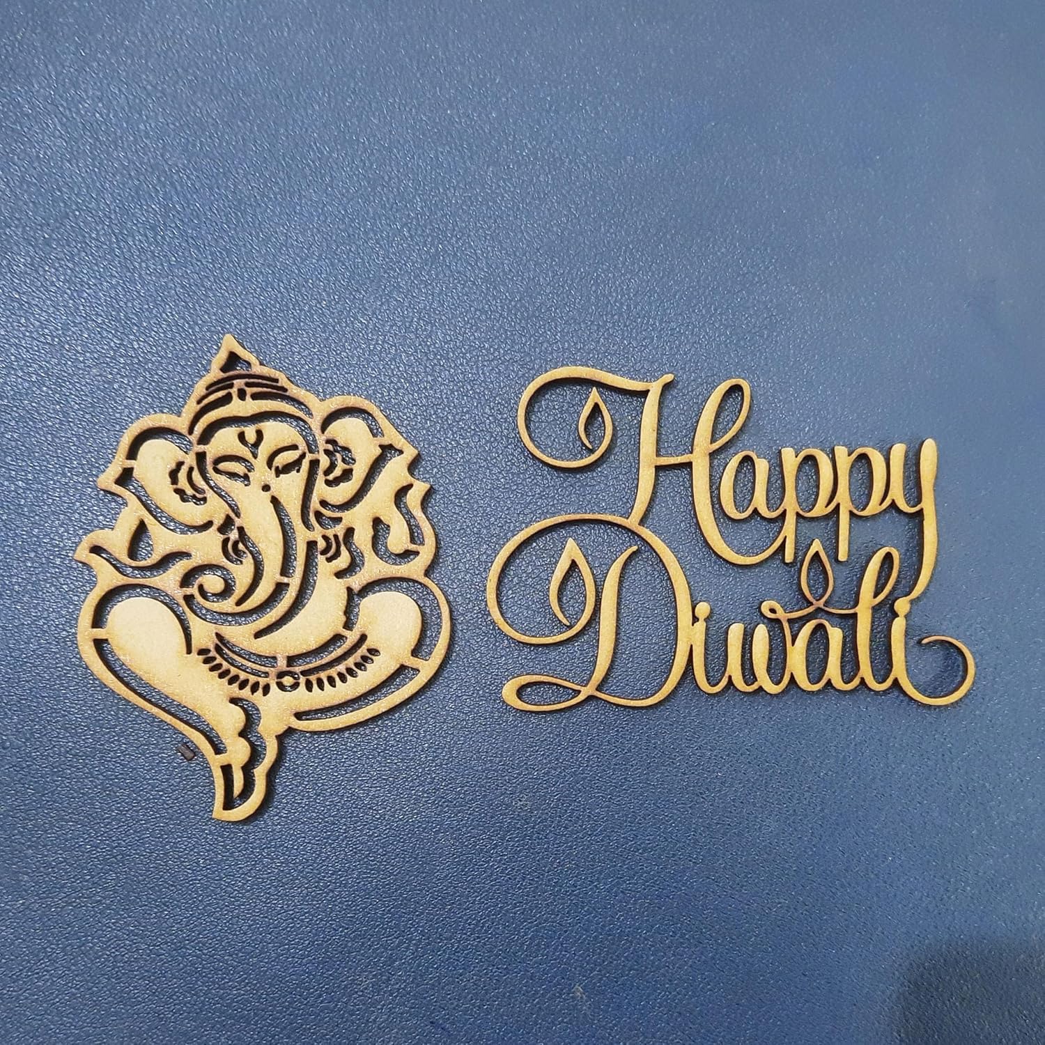 Decorative cutout of Ganesha and 'Happy Diwali' text on a blue background
