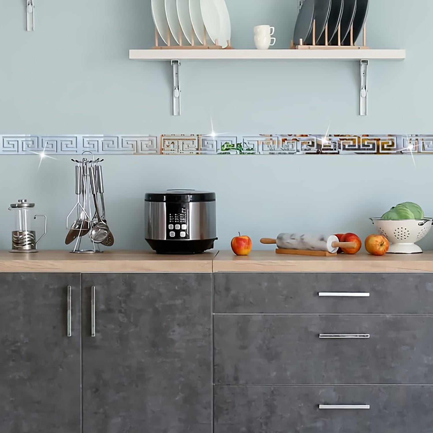 Modern kitchen with gray cabinets, wooden countertop, and various kitchen items.