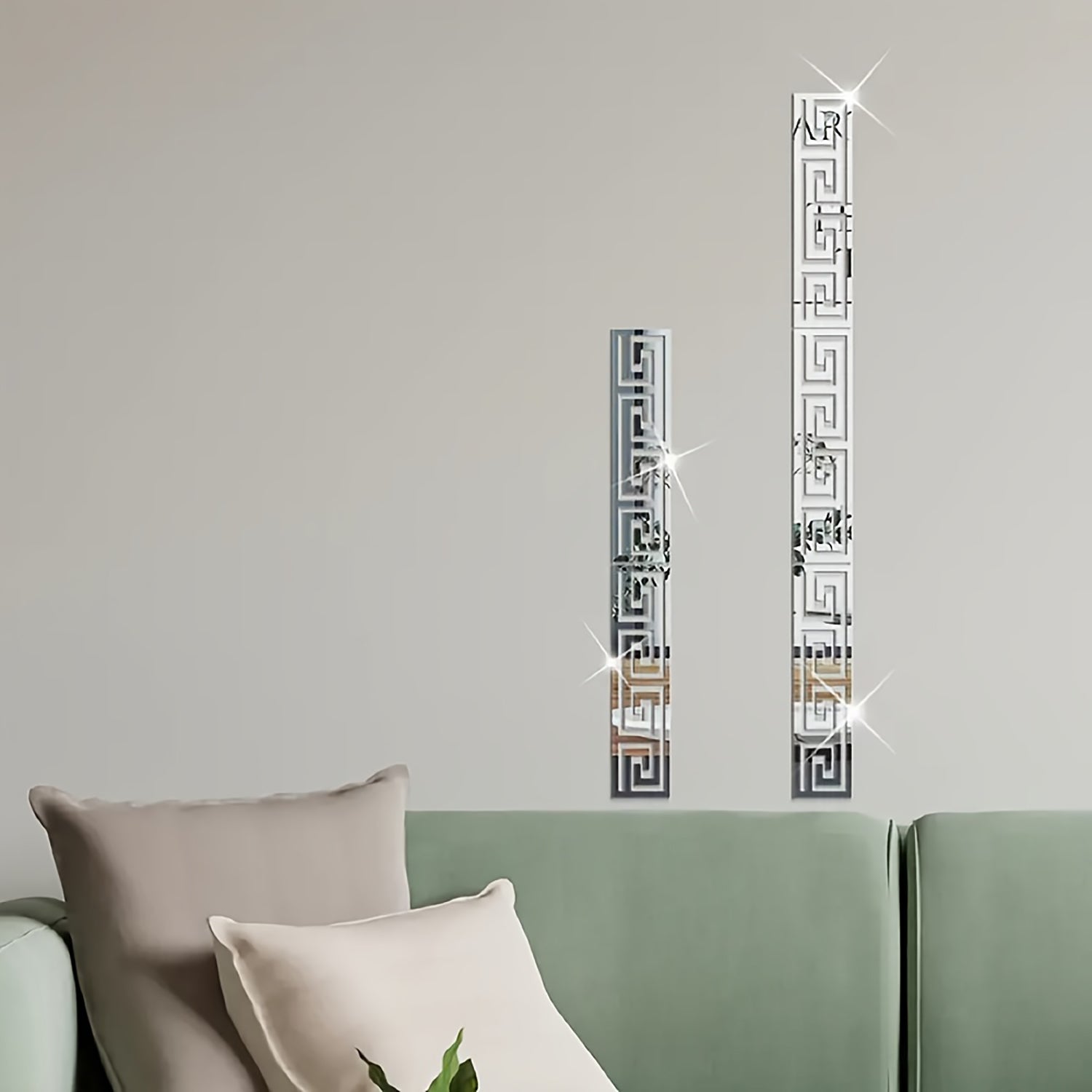 Decorative wall mirrors with geometric patterns on a neutral wall above a sofa.