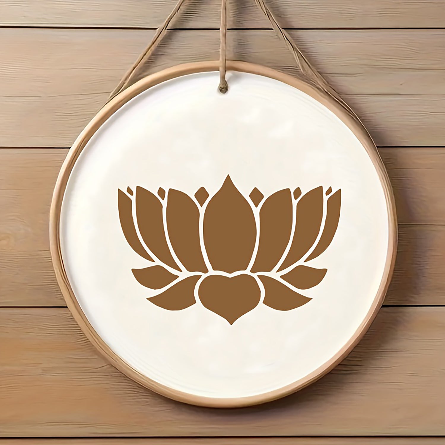 Decorative wall hanging with a brown lotus flower design on a white background, hanging against a wooden wall.