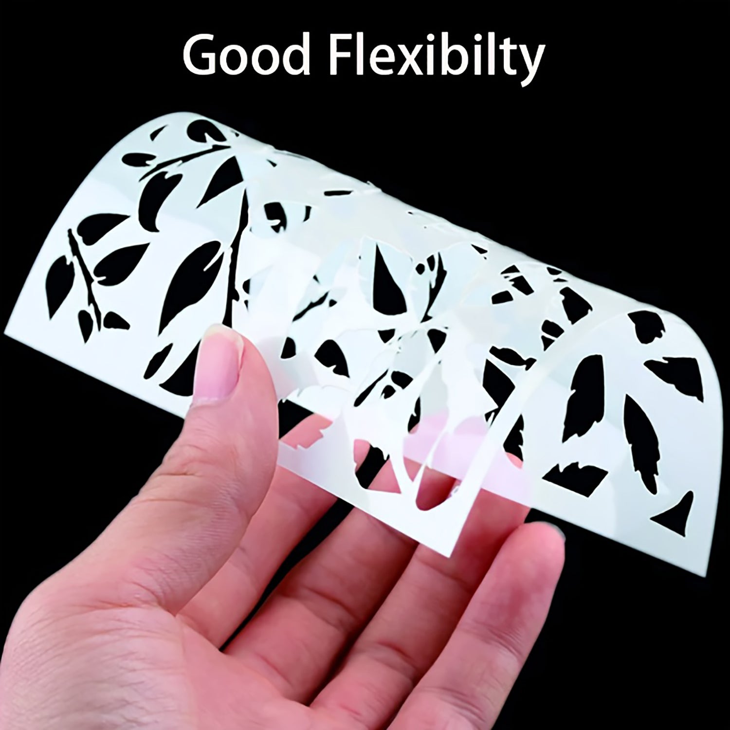 Hand holding a flexible leaf-patterned stencil with text 'Good Flexibility' on a black background