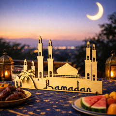 Decorative mosque model with 'Ramadan' on a table at sunset.