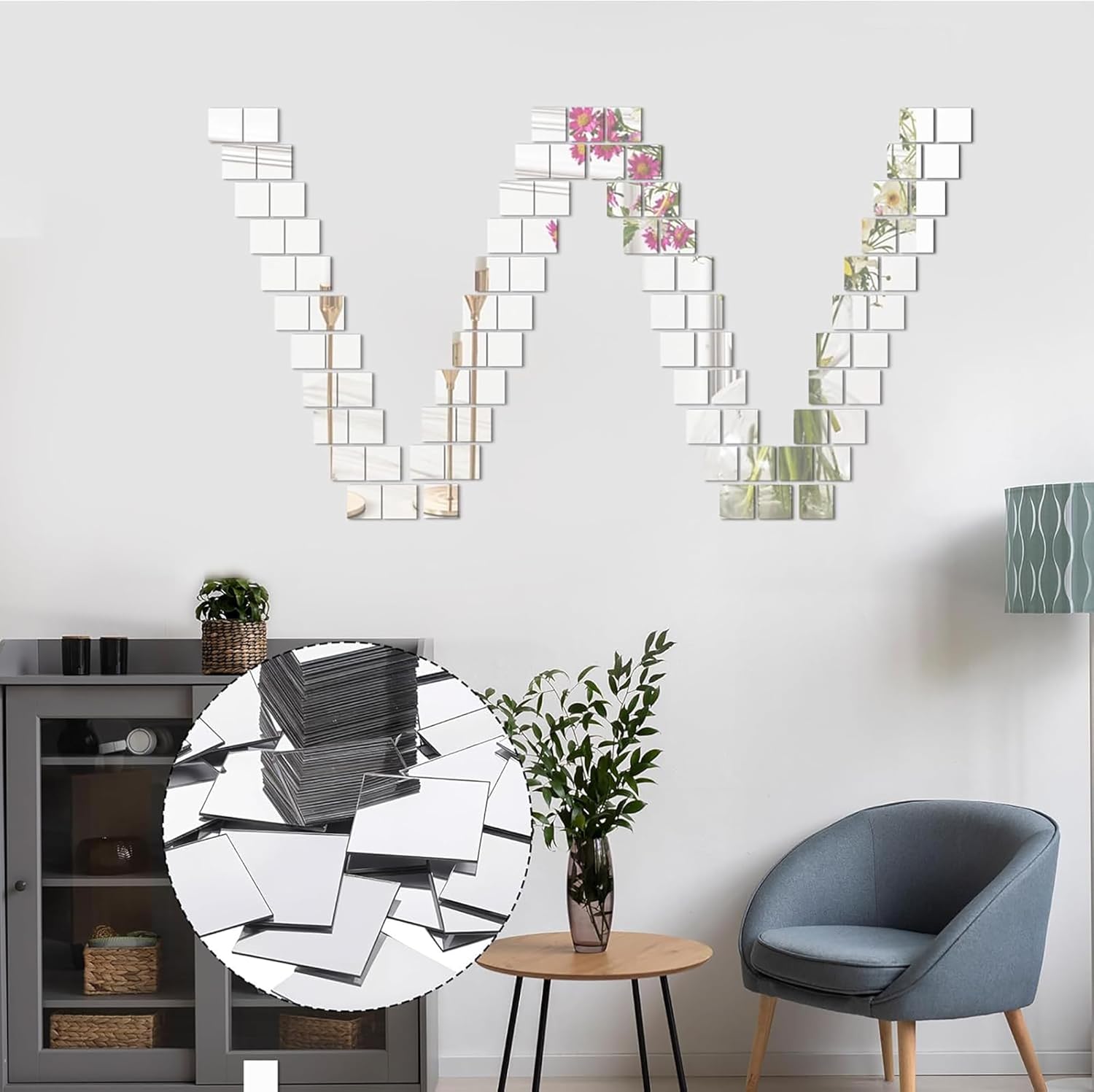 Decorative wall mirrors with floral arrangements on a white wall, with a gray chair and small table in the foreground.