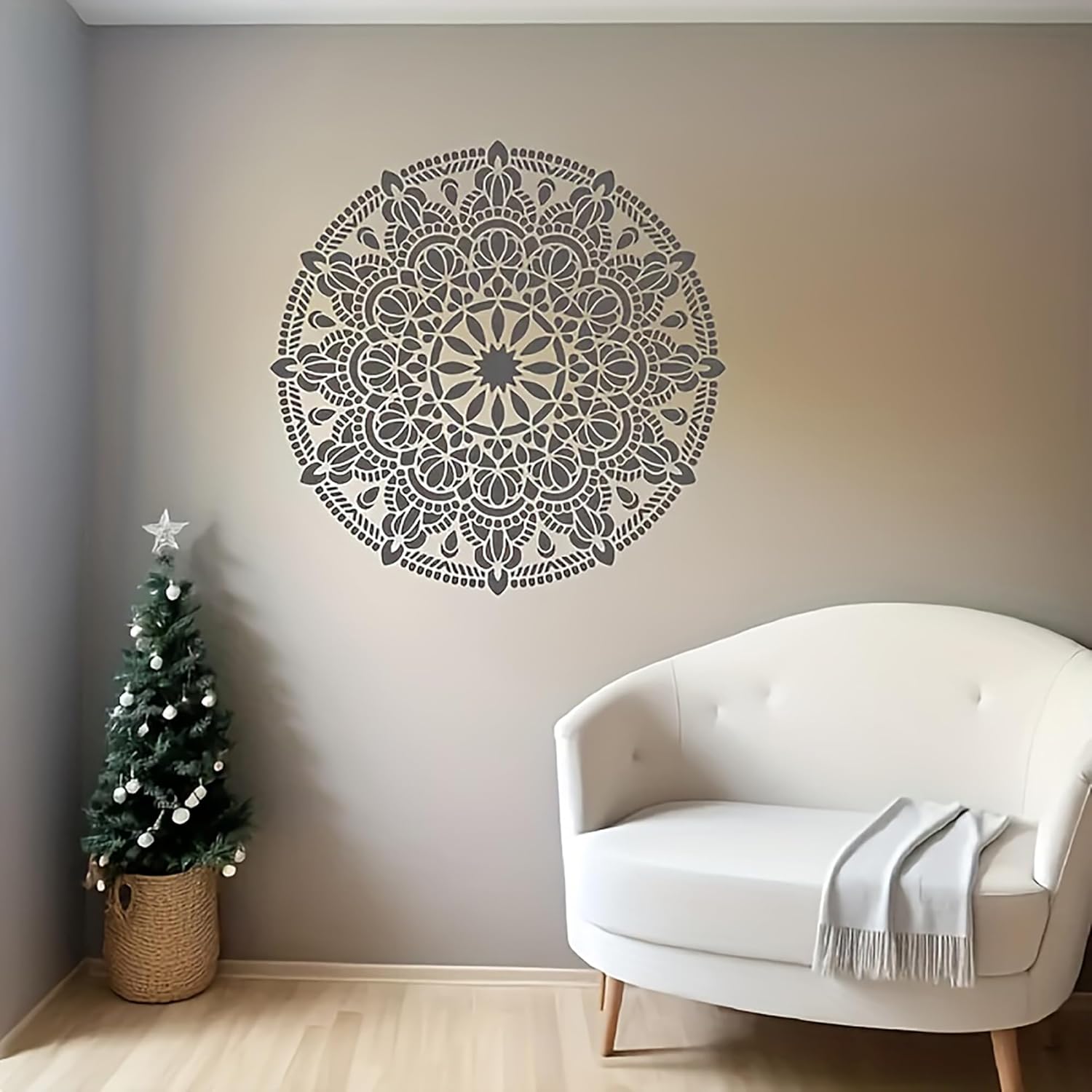 Decorative wall mandala in a room with a white armchair and small Christmas tree.