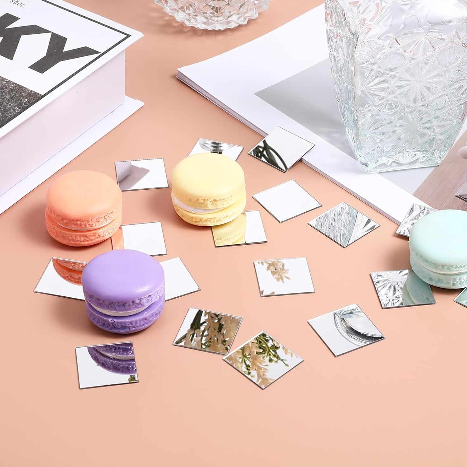 Colorful macaron cookies with decorative cards on a pink surface