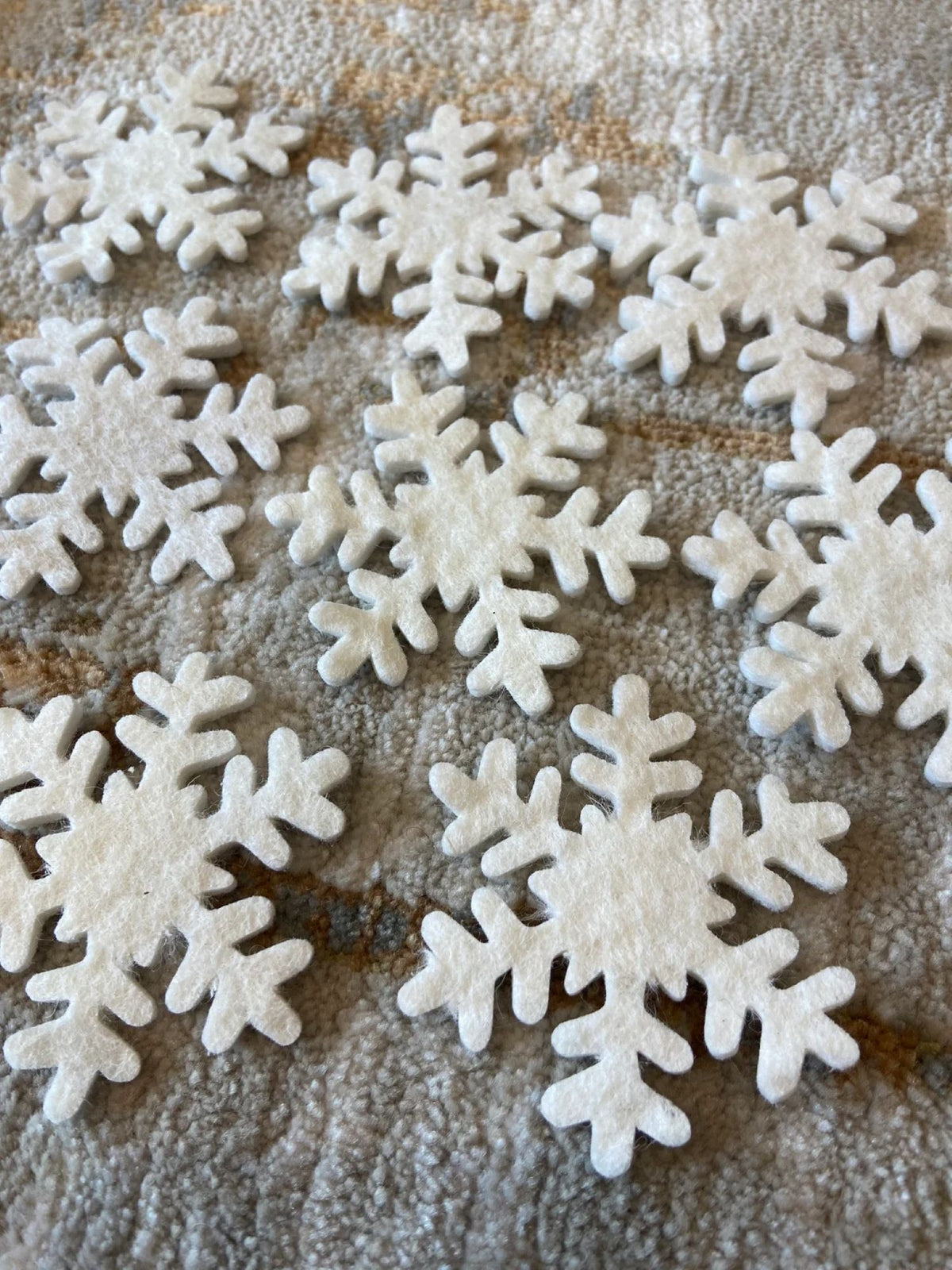 White snowflake-shaped cookies on a textured surface