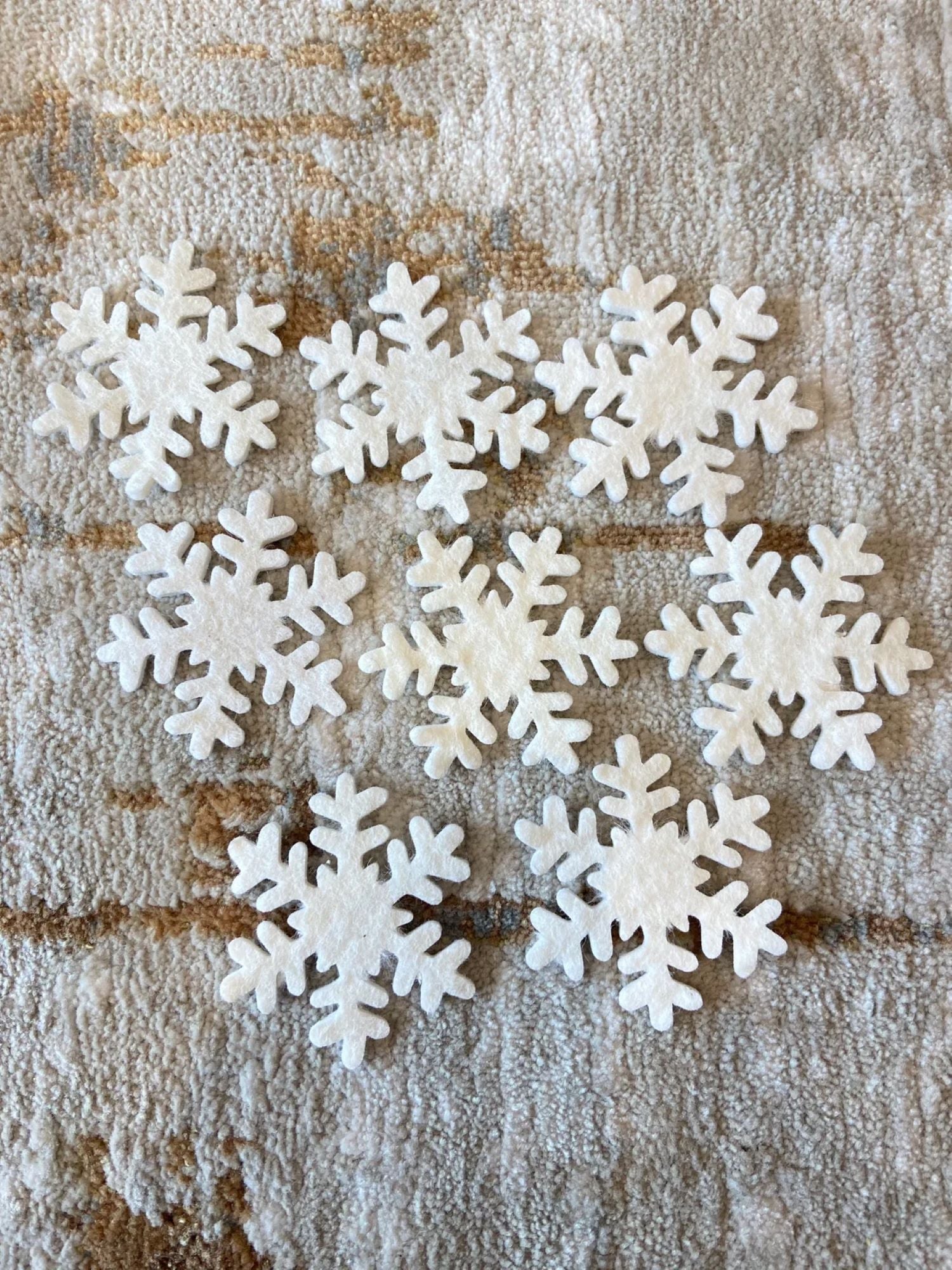 White snowflake decorations on a textured brown surface