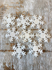 White snowflake decorations on a textured brown surface